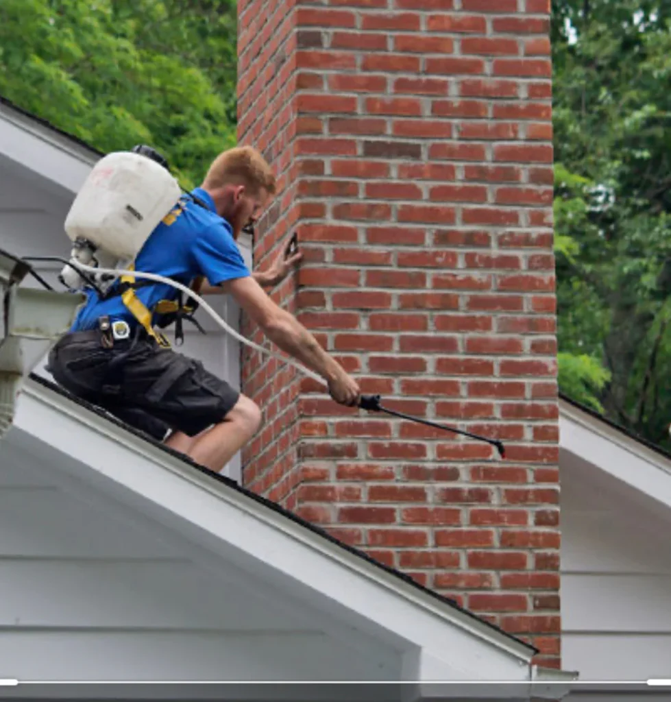 A chimney sweeper cleaning a chimney. The sweeper is wearing traditional clothing and is using a brush to clean the soot from the chimney.
