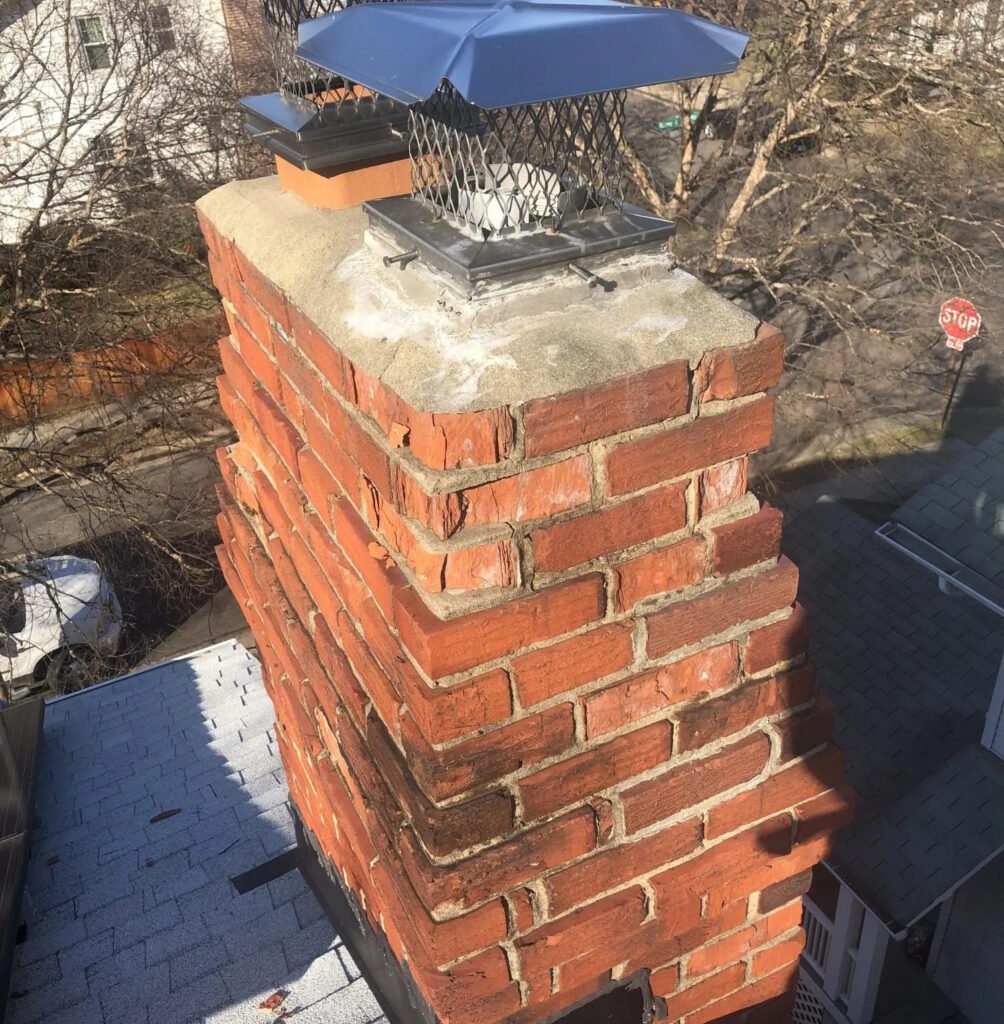 A brick chimney topped with a blue bird, set against a clear sky, showcasing a charming outdoor scene.