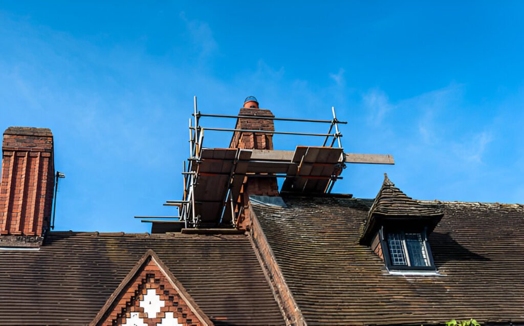 A brick chimney under restoration with scaffolding set up on a historic-style rooftop, ensuring structural integrity and long-term safety.
