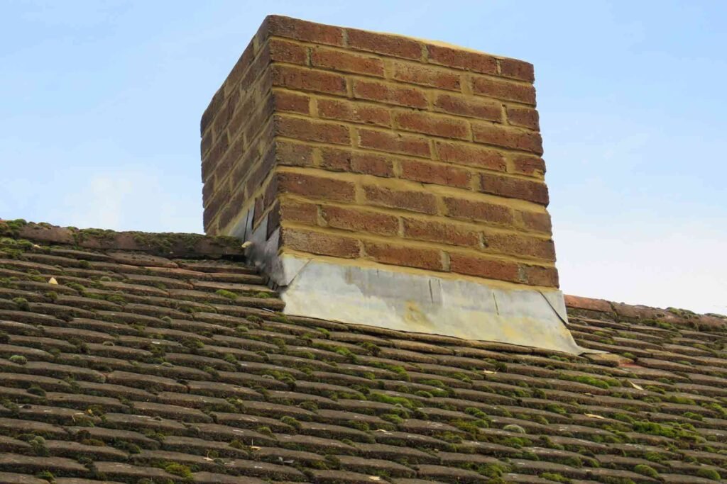 A brick chimney with a matching brick roof and a decorative chimney cap, showcasing traditional architectural design.